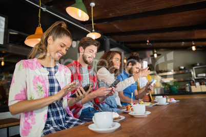 Friends using their mobile phones in restaurant