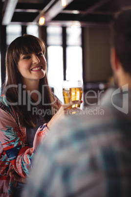 Happy couple interacting while having beer at counter