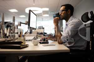 Thoughtful businessman working on computer in office