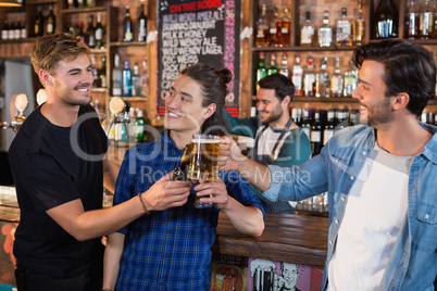 Happy male friends toasting beer mugs and bottle