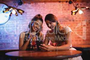 Two young women using mobile phone