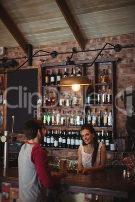 Female bar tender interacting with customer