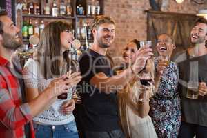 Friends laughing together while holding drinks