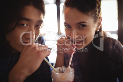 Portrait of couple having milkshake