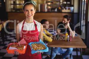 Waitress holding burger and french fries in tray