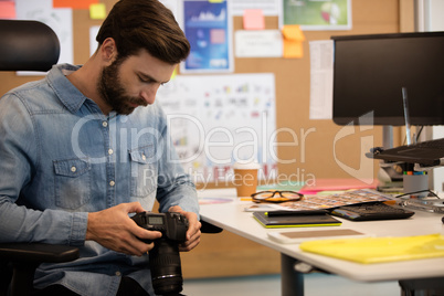 Professional photographer using camera in creative office