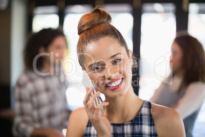 Beautiful young woman talking on phone in restaurant