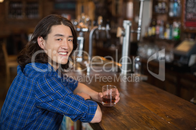 Young man using laptop at bar counter