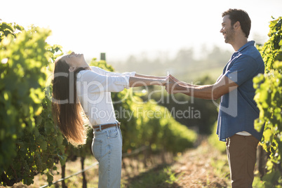 Happy young couple holding hands at vineyard