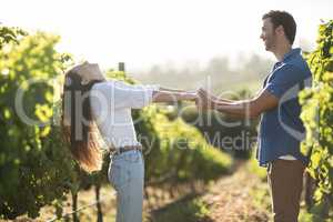 Happy young couple holding hands at vineyard