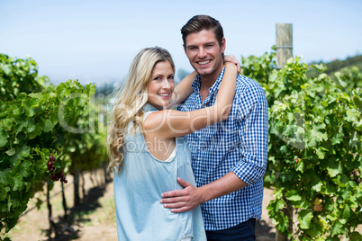 Portrait of smiling young couple embracing at vineyard