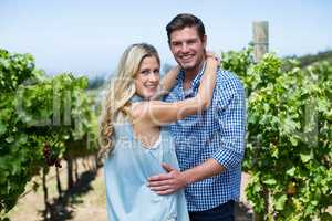 Portrait of smiling young couple embracing at vineyard