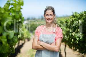 Portrait of female farmer with arms crossed at vineyard
