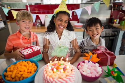 Portrait of siblings celebrating birthday in kitchen