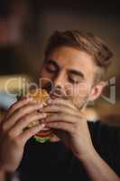 Close-up of man eating burger