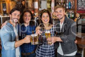Portrait of friends tossing beer glasses and bottles in pub