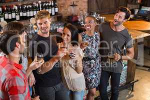 Happy friends holding drinks in bar