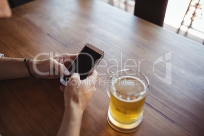 Man using mobile phone while having beer