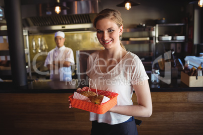 Waitress holding burger in tray