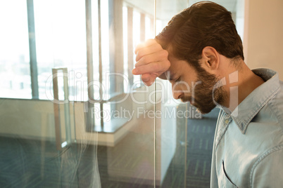 Depressed businessman leaning on glass