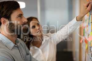 Serious businessman analyzing charts with female colleague