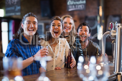 Cheerful friends standing by bar counter
