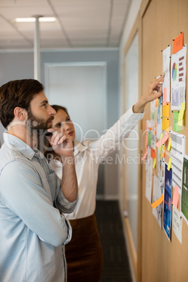 Serious businessman with female colleague analyzing charts