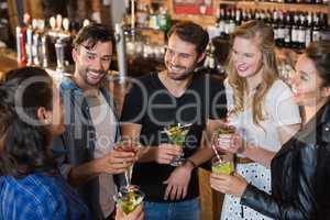 High angle view of smiling friends holding drinks while standing together