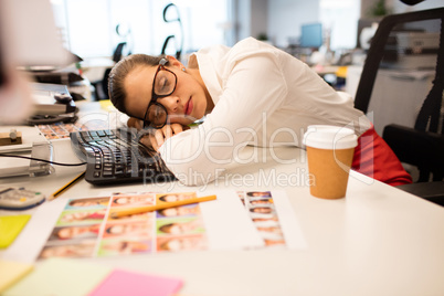 Tired businesswoman napping in creative office