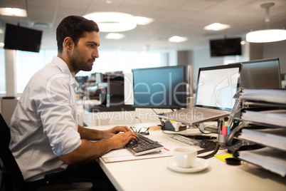 Focused businessman using desktop pc in office
