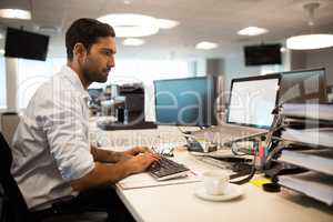 Focused businessman using desktop pc in office