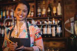 Portrait of waitress taking an order on notepad