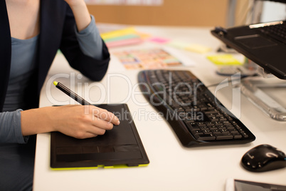 Businesswoman working on digitizer at desk
