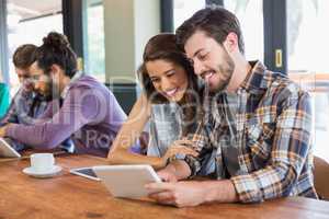 Friends watching tablet pc in restaurant