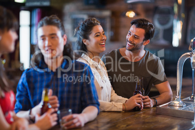 Cheerful friends interacting at bar counter