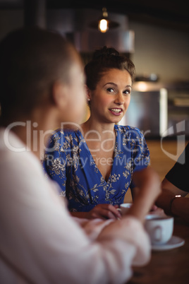 Happy friends interacting while having coffee