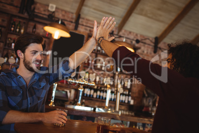 Two young men giving high five to each other