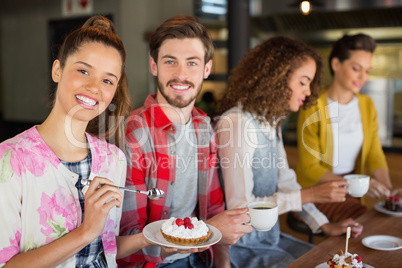 Friends having coffee and dessert in cafe