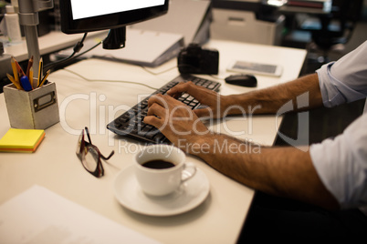 Cropped hands of businessman typing on keyboard