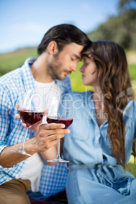 Romantic young couple holding red wine glasses