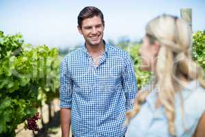 Smiling man looking at woman in vineyard