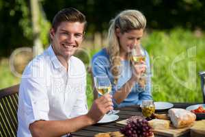 Happy couple holding wineglasses at table