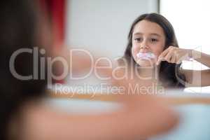 Girl brushing her teeth in bathroom