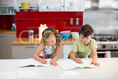 Siblings doing homework in kitchen