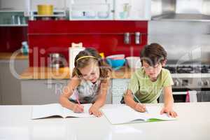 Siblings doing homework in kitchen
