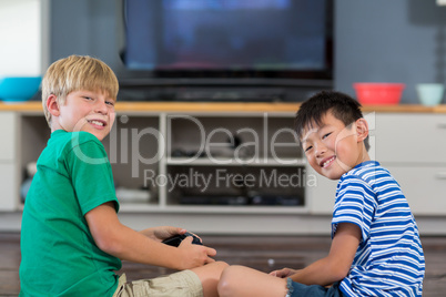 Happy siblings playing video games in living room