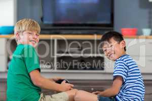 Happy siblings playing video games in living room