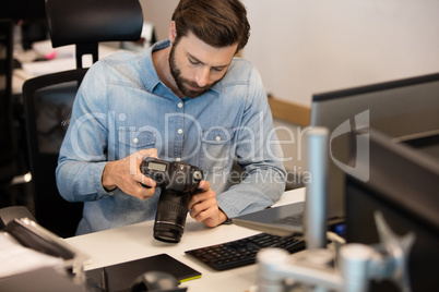 Professional photographer using camera in creative office