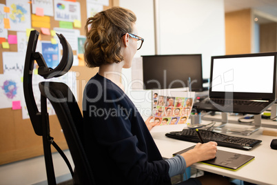 Businesswoman working on digitizer at desk