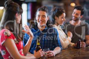 Happy friends interacting at bar counter